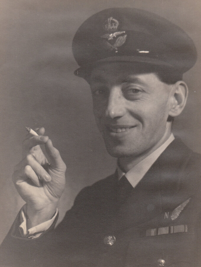 Arthur White in uniform, smiling and holding a cigarette