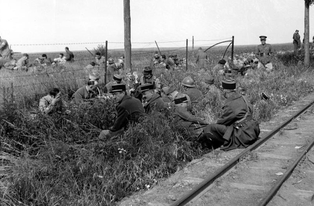 French and British prisoners of war resting beside railway tracks