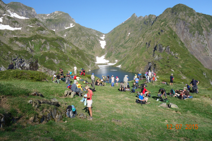 Chemin de la Liberte walkers gathered beside a mountain lake